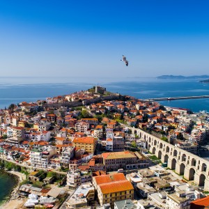 1065709694-Aerial view the city of Kavala in northern Greek, ancient aqueduct Kamares, homes and medieval city wall-Ververidis Vasilis.jpg